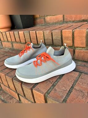 Grundéns SeaKnit boat shoes in grey featuring bright orange laces.